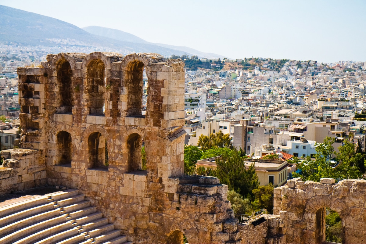 Stone arches of the Odeon of Herodes Atticus amphitheater on the Acropolis in Athens, overlooking the city below, a classic stop on an Athens in 1 day itinerary.