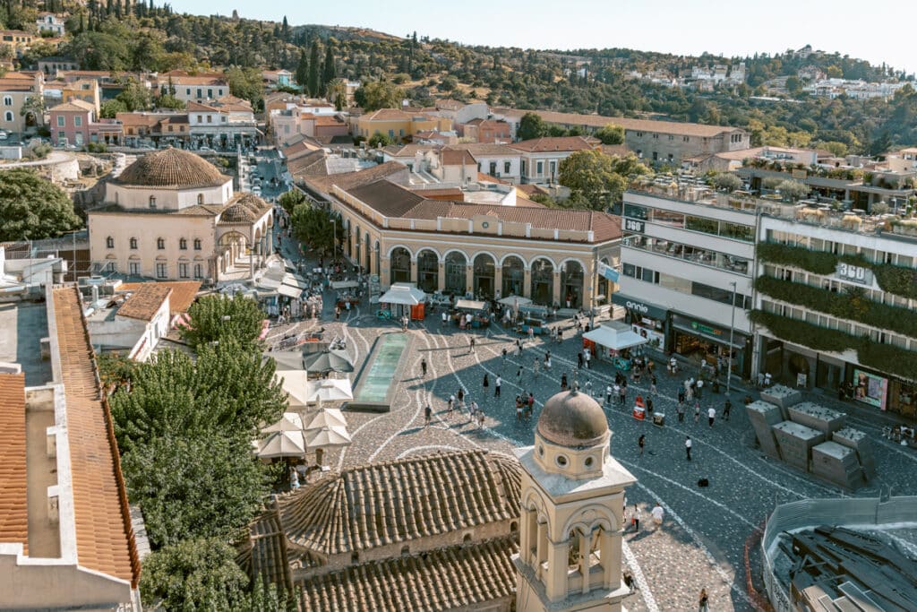 A busy afternoon in Monastiraki Square with its fountain, shops, and rooftop bars, surrounded by vibrant crowds and historic buildings. Captures the energy of Athens’ central neighborhoods showcasing the best time to visit Athens.