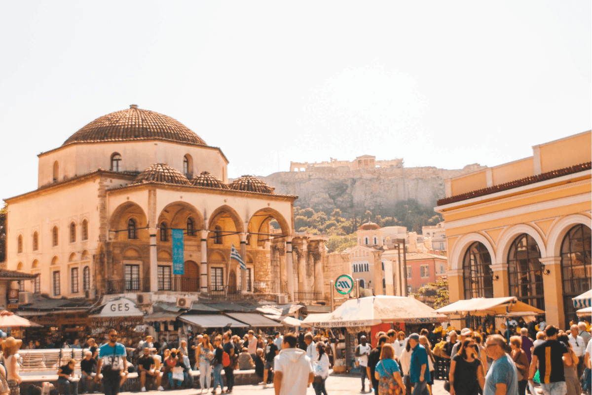Is Athens safe for travelers visiting busy Monastiraki Square with the Acropolis in the background.