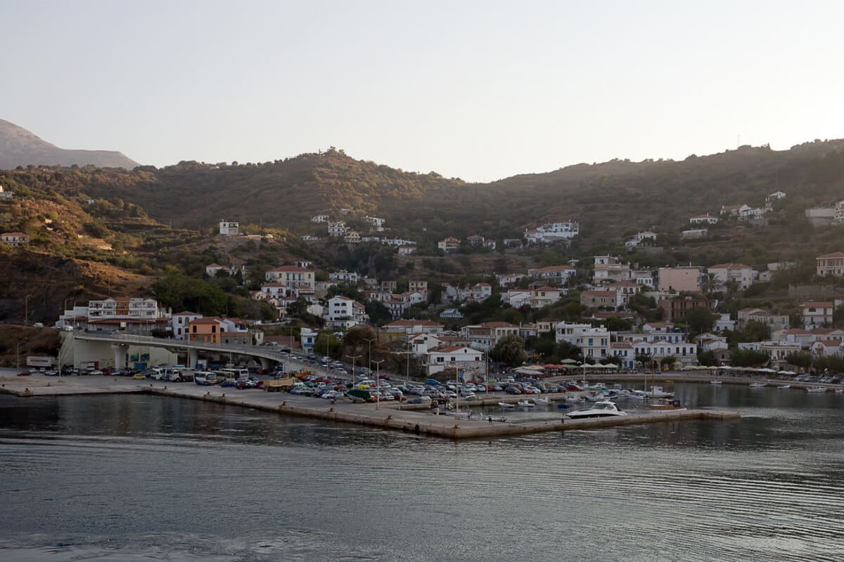 The harbor at Agios Kirykos, Ikaria’s capital, at sunset, with boats and houses lining the hills—a peaceful introduction to island life and a highlight in any Ikaria travel guide.