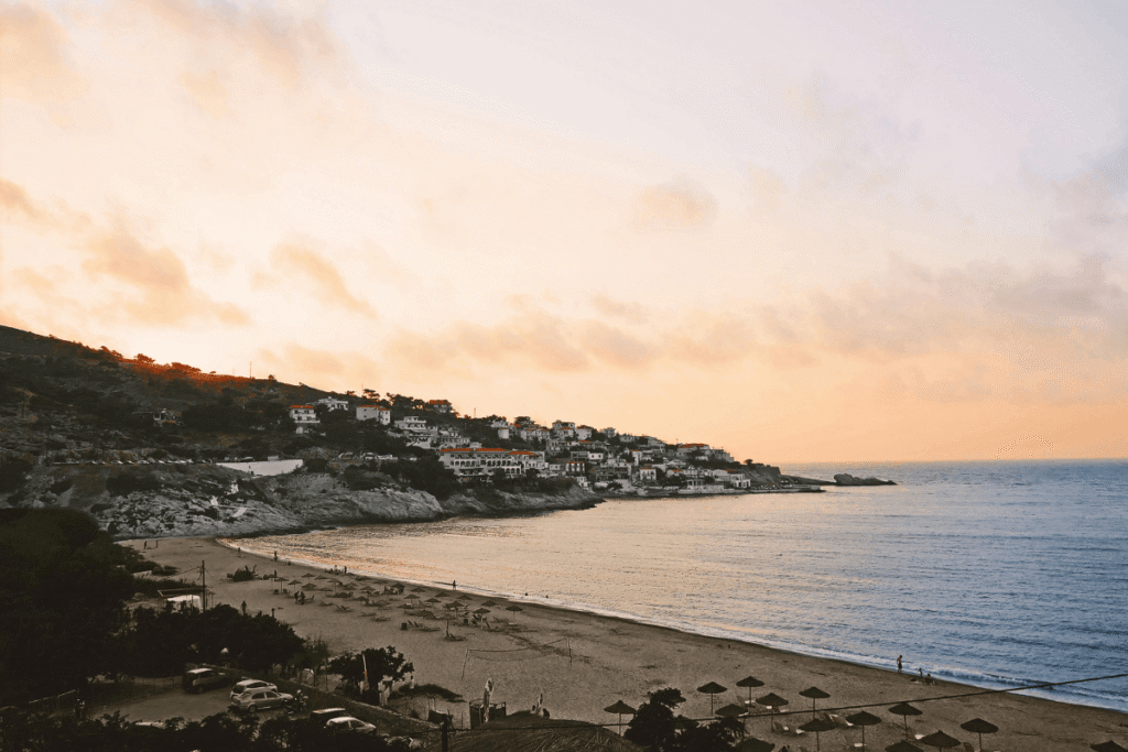 Ikaria beach and coastal village at sunset, highlighting the island’s mountainous seaside scenery in this Ikaria travel guide.