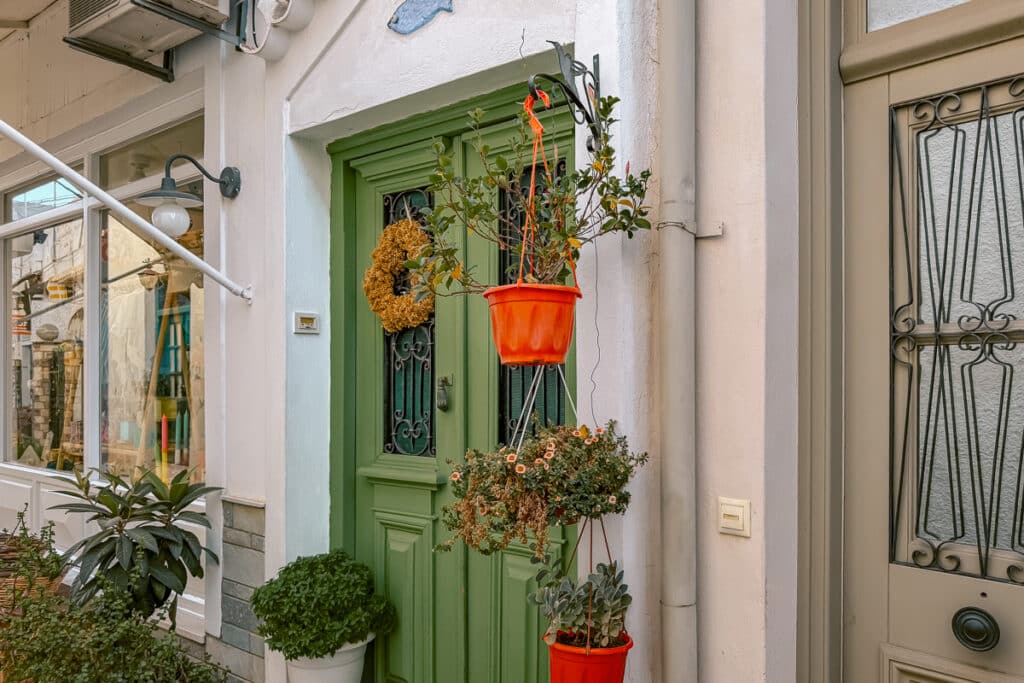 Green doorway with hanging flower pots in Spetses Town, Greece