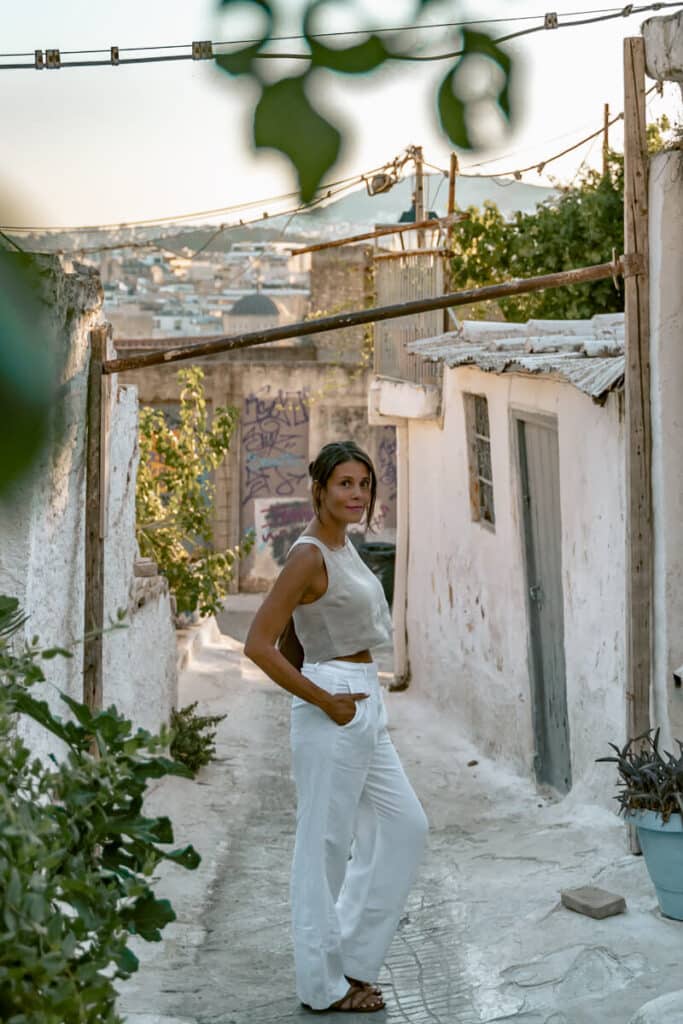 Me standing in a rustic alley in Athens at golden hour with city views behind,  is Greece safe for solo female travelers in urban areas.