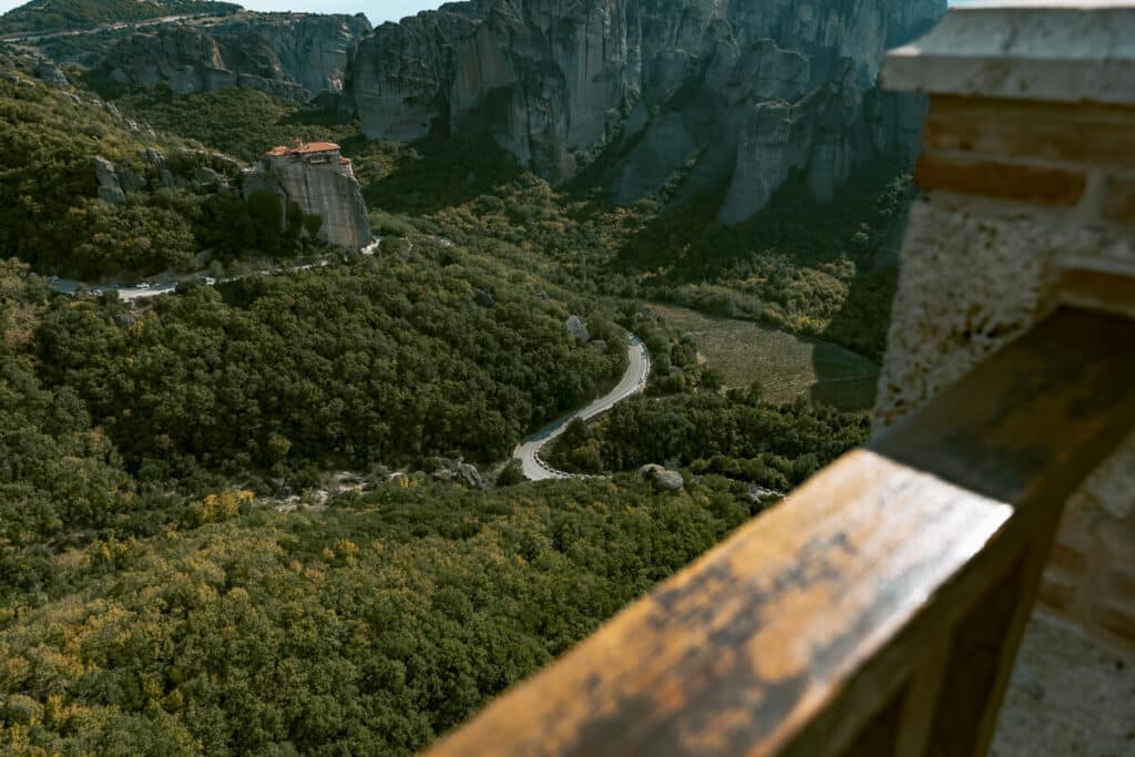 View of Meteora’s rock formations and monastery from a balcony in Greece.
