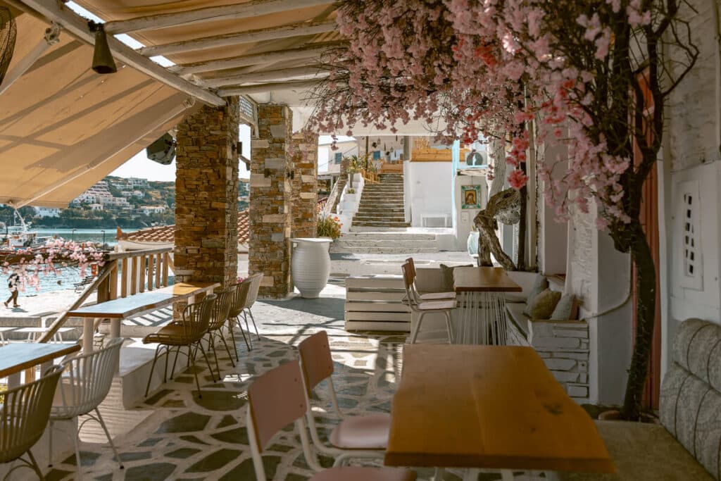 Greek island cafe in Andros with whitewashed steps and sea views, perfect for a relaxed solo female travel stop in Greece.