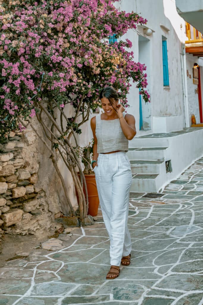 Me walking under blooming bougainvillea in a cobblestone Greek street in Sifnos.