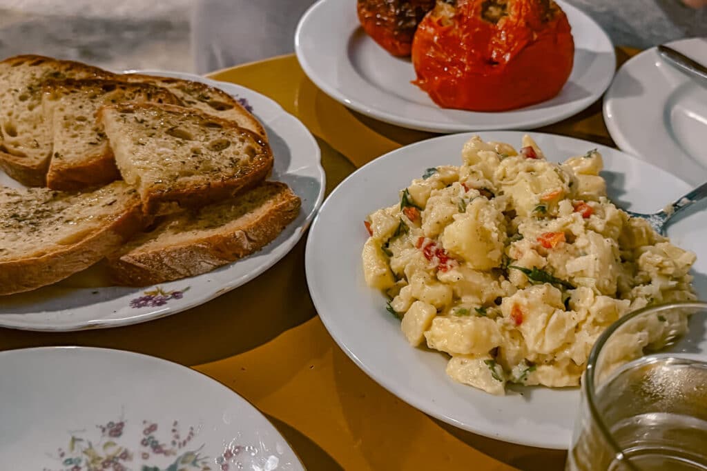 Apanemiá in Astypalaia, with toasted bread, creamy potatoes, and stuffed tomato on a taverna table.