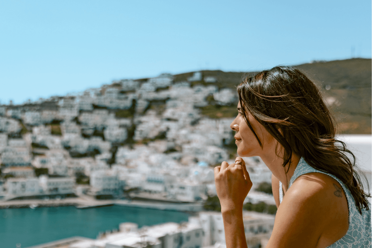 Solo female traveler overlooking a whitewashed Greek island and the Aegean Sea, answering is Greece safe for solo female travel.