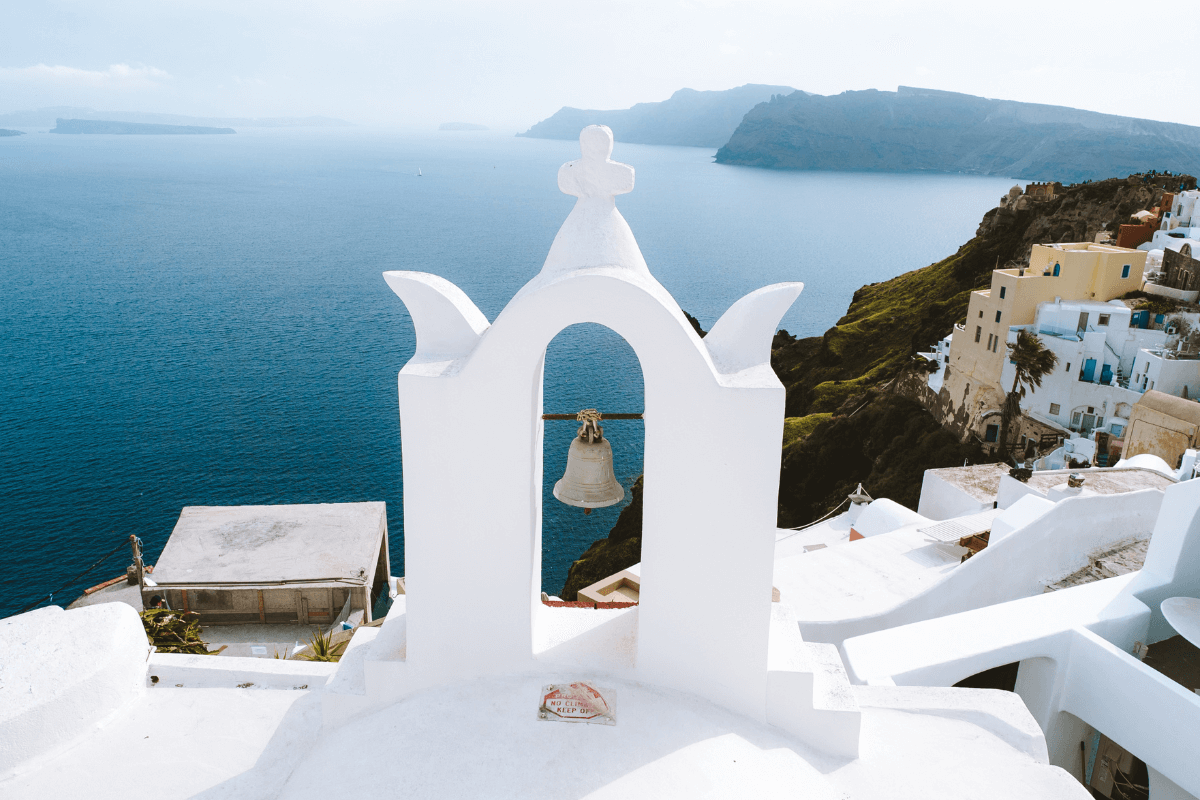 Santorini bell tower viewpoint over the caldera and whitewashed buildings, a classic stop on a 1 week in Greece itinerary for travelers mixing Athens and Greek islands.