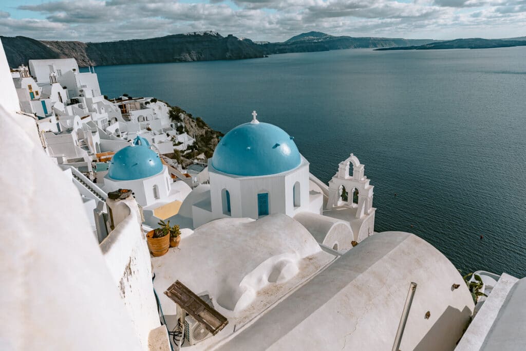 View of the famous Santorini caldera and whitewashed houses from above, featuring the blue-domed churches of Oia in winter
