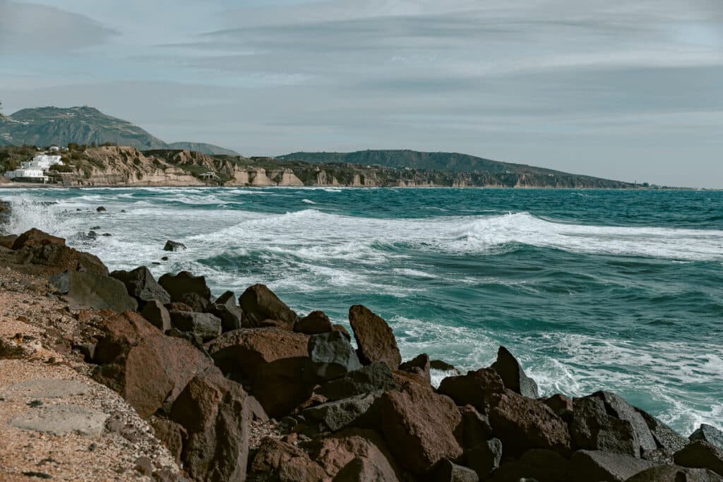 Waves crashing on the rocky volcanic shoreline of southern Santorini in winter