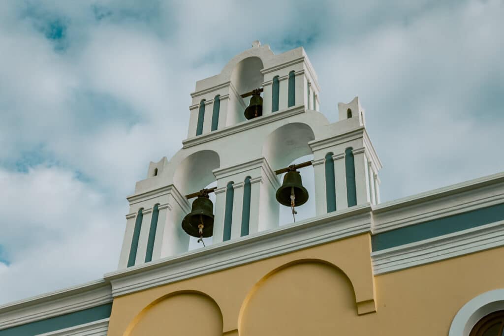 Traditional Greek church bell tower against a cloudy winter sky in Santorini