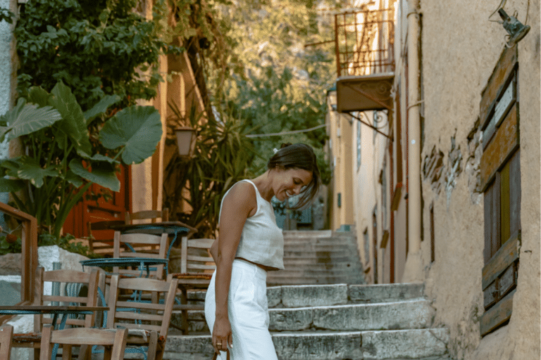 exploring a quiet, leafy street with stone steps and outdoor cafés during solo travel to Athens.