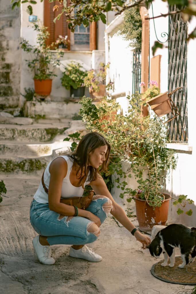 Me exploring the Acropolis in Athens, standing confidently in front of ancient stone columns with one hand in her pocket and the other brushing her hair. The dramatic sky adds contrast to the scene, reflecting the sense of awe that often comes with solo travel to Athens.