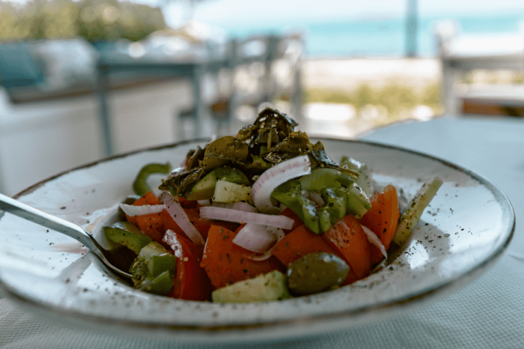 Fresh Greek salad with a seaside view, highlighting local cuisine you must try when exploring things to do in Agistri.