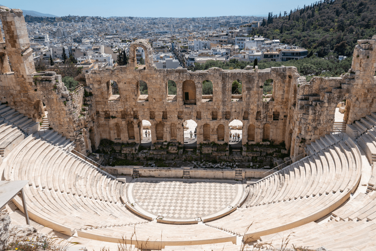 Ancient Odeon of Herodes Atticus amphitheater in Athens with stone seating and city views in the background, showcasing a historic highlight often included in a 5 day Greece itinerary.