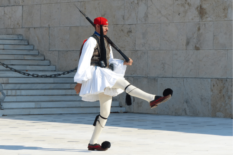 Evzone guard in traditional uniform performing the ceremonial march at Syntagma Square, one of the free things to do in Athens.