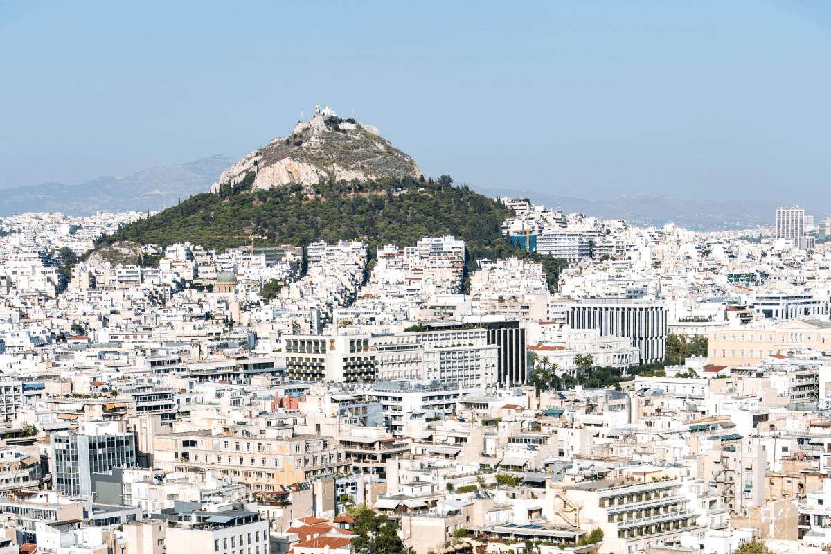 Panoramic view of Athens in April with Lycabettus Hill rising above the city under a clear blue sky