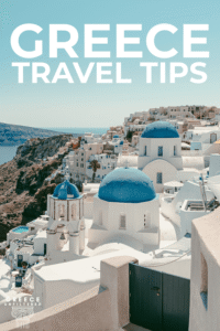 Pinterest pin with the text “Greece Travel Tips” over a Santorini view of white buildings and blue domes overlooking the caldera.
