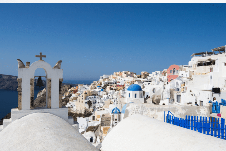Whitewashed buildings and blue domed churches overlooking the Aegean Sea in Santorini, perfect for planning how many days in Greece.