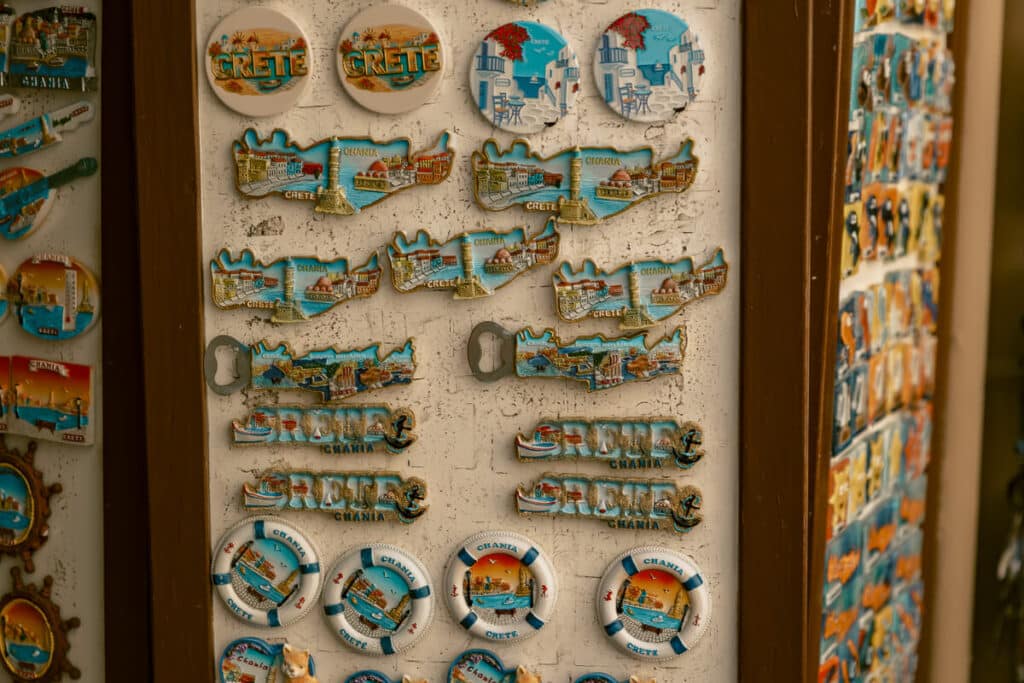 Souvenir magnets showing Chania and Crete scenes displayed outside a shop in Old Town. One of the many things to do in Chania is shop for souvenirs.