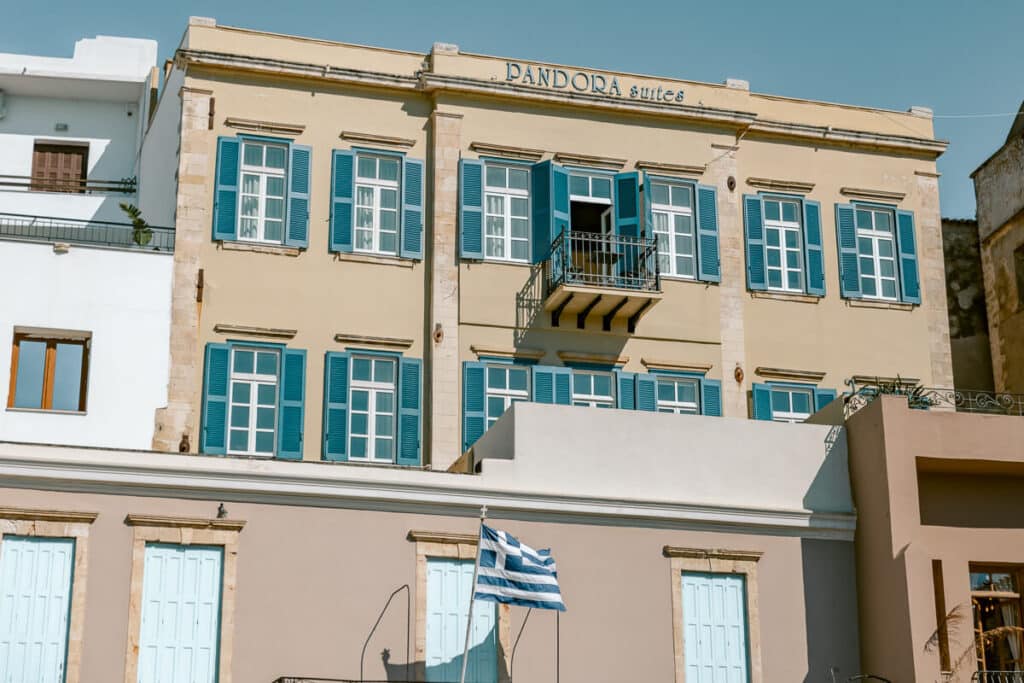 Historic building with blue shutters and a Greek flag in Chania, reflecting the architecture and charm of Old Town
