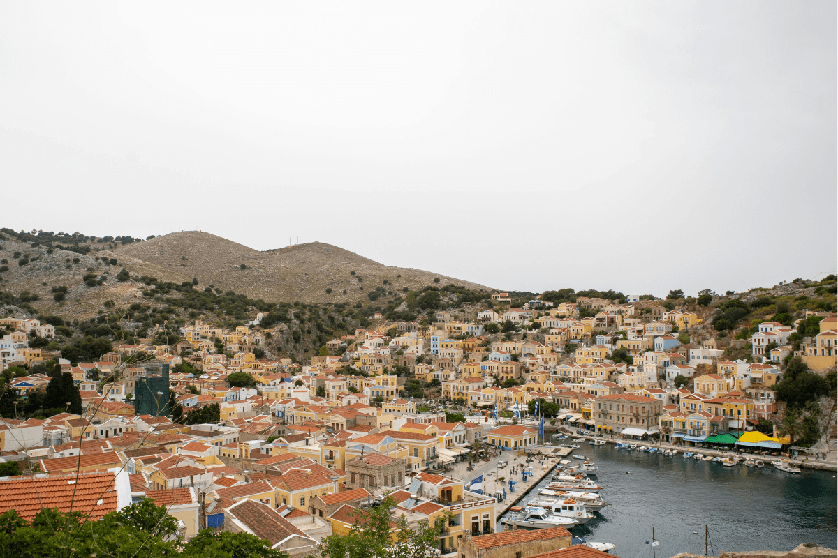 Colorful neoclassical houses surrounding the harbor on Symi, a scenic arrival on a day trip to Symi from Rhodes.