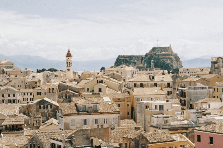 Terracotta rooftops and historic buildings in Corfu Old Town with the Old Fortress rising in the background, one of the sights to see when exploring things to do in Corfu Old Town.