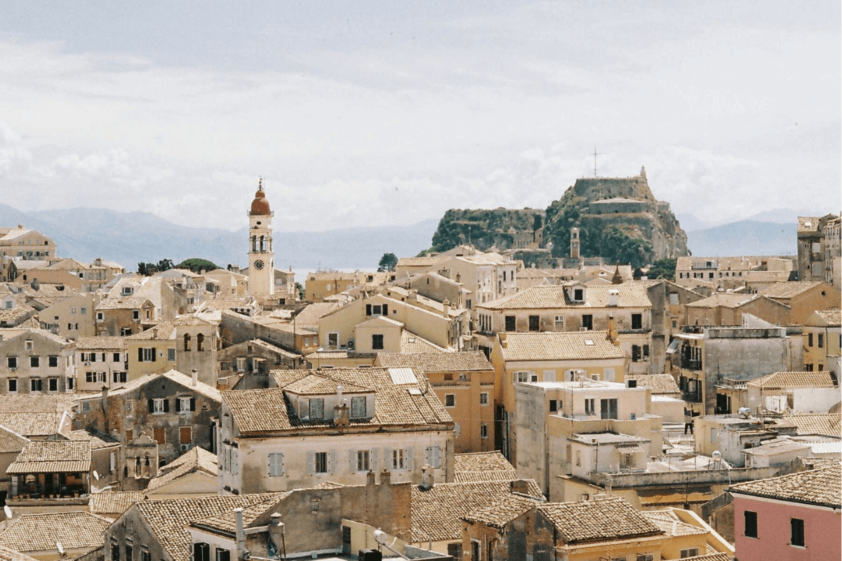 Terracotta rooftops and historic buildings in Corfu Old Town with the Old Fortress rising in the background, one of the sights to see when exploring things to do in Corfu Old Town.
