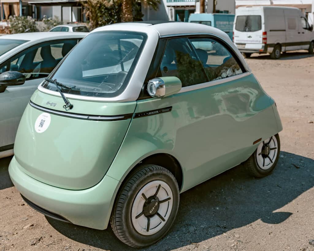 Small mint green rental car parked in Serifos, Greece, used for exploring the island and reaching beaches beyond the bus routes.
