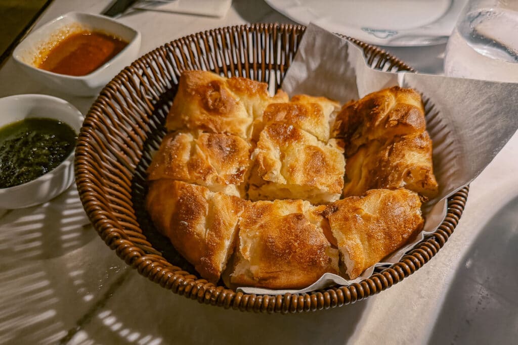 Basket of golden baked focaccia cut into pieces and served with two dipping sauces at a restaurant in Spetses.
