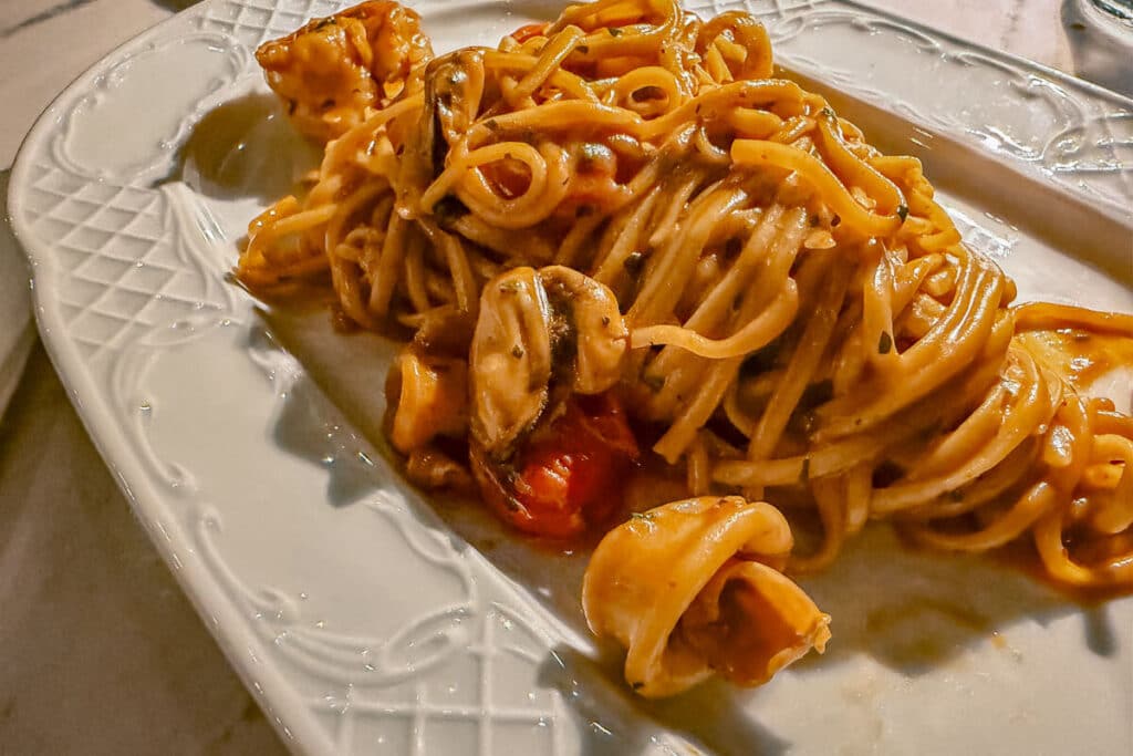 Plate of seafood pasta with mussels, shellfish, and tomato sauce at a restaurant in Spetses.