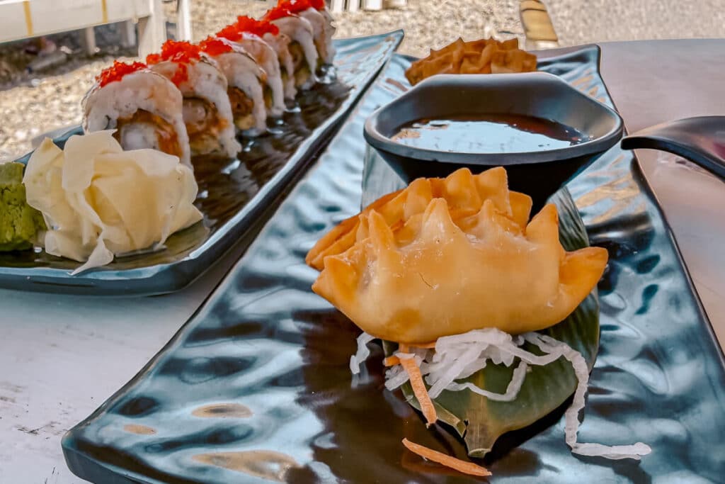 Fried dumplings with dipping sauce and a sushi roll served at Kaiki Beach Club in Spetses.